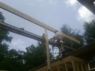 Carpenter setting a ridge beam over a new addition frame — Ice Dam Removal by Roofing Brothers in Mount Enterprise