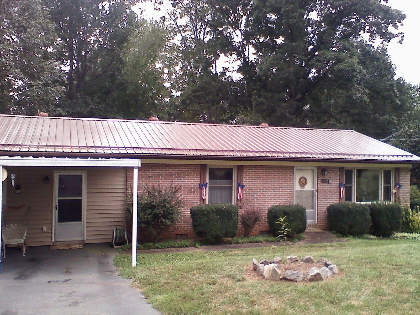 Bronze metal roof and carport on a brick ranch home — Roof Repair work by our crew in Mount Enterprise